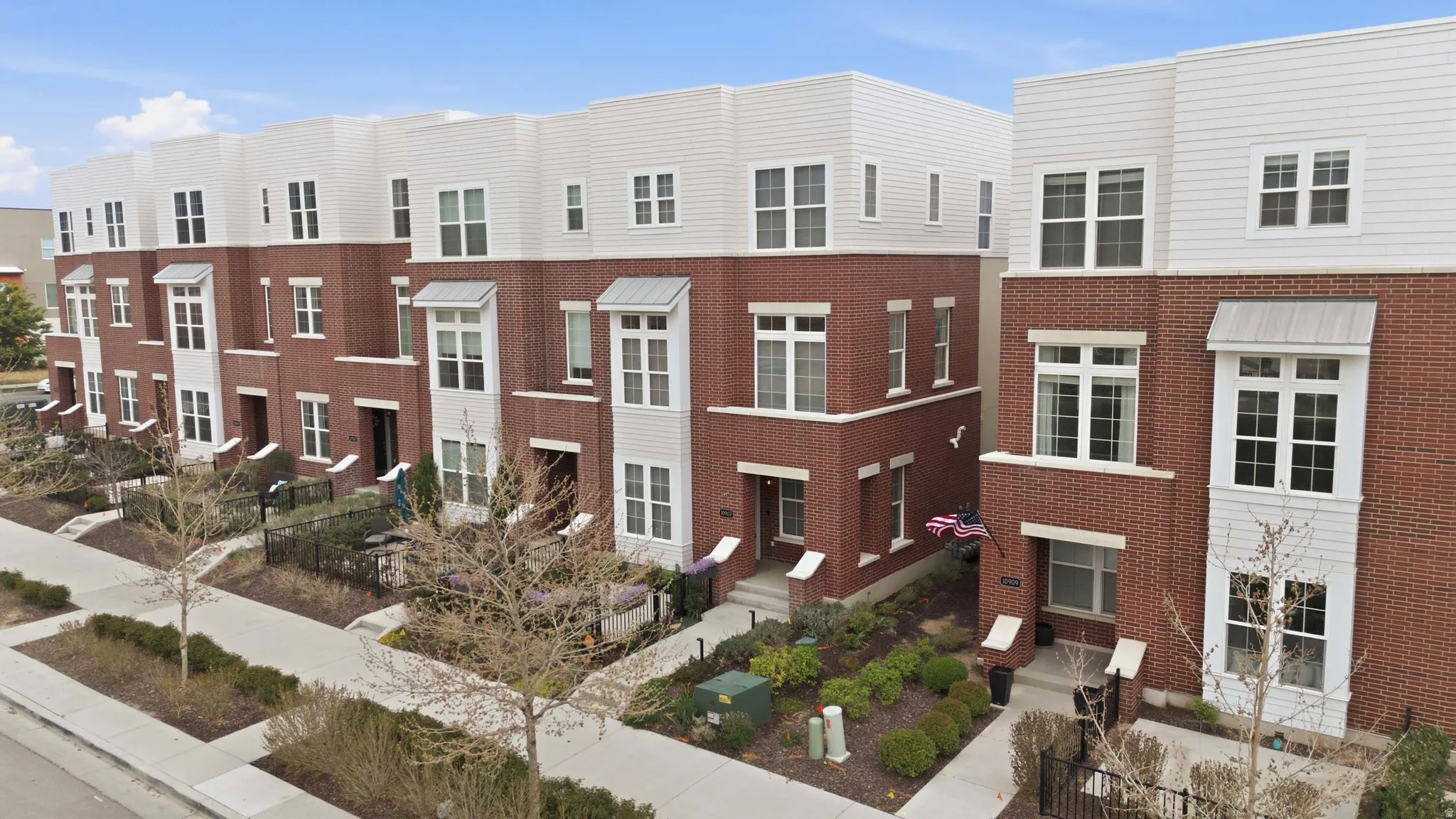 Townhome row featuring brick and white siding exteriors