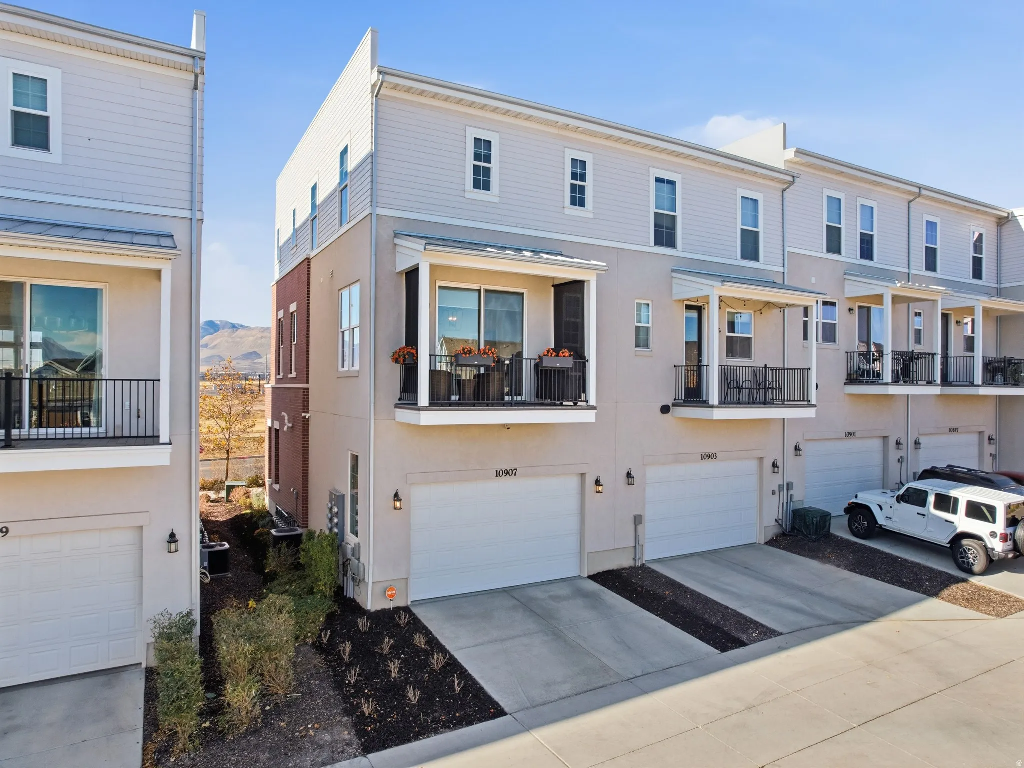 Traditional home with a balcony, concrete driveway, and stucco siding