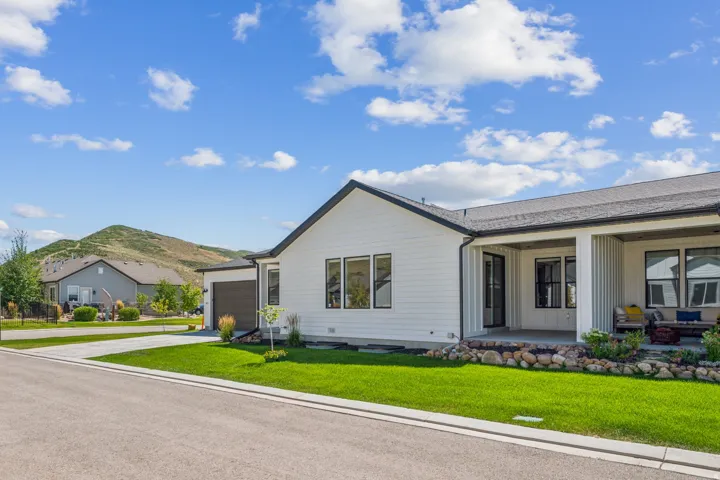 Ranch-style house featuring a patio area, concrete driveway, a front yard, and an attached garage