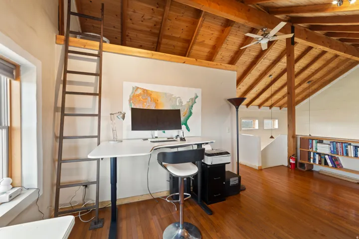 Office space with dark wood finished floors, wood ceiling, and a ceiling fan