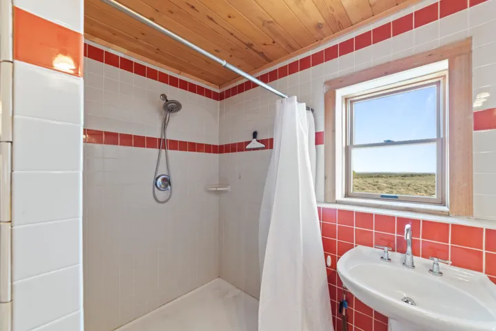 Bathroom with a stall shower, tile walls, and wooden ceiling