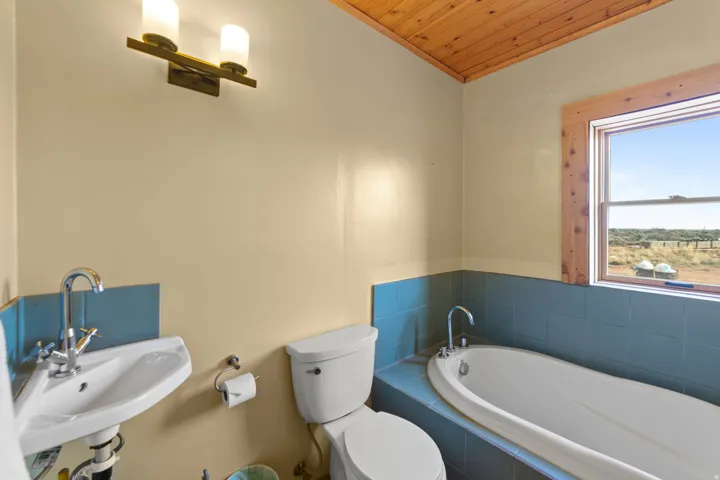 Full bath with a garden tub, wood ceiling, and vaulted ceiling