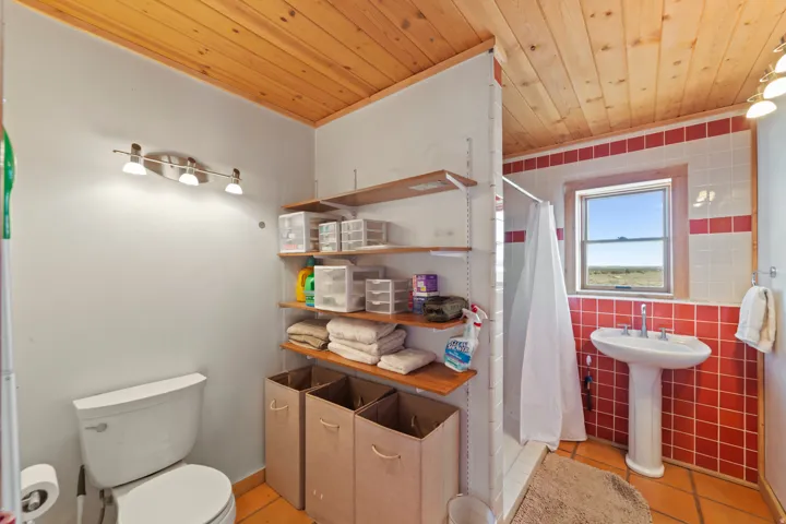 Bathroom with a shower stall, light tile patterned floors, wooden ceiling, and tile walls