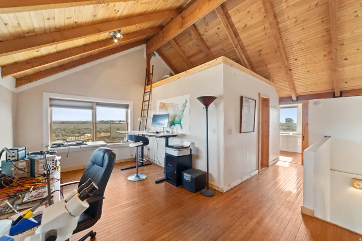 Office space featuring a wood ceiling with exposed beams, light wood finished floors, and high vaulted ceiling