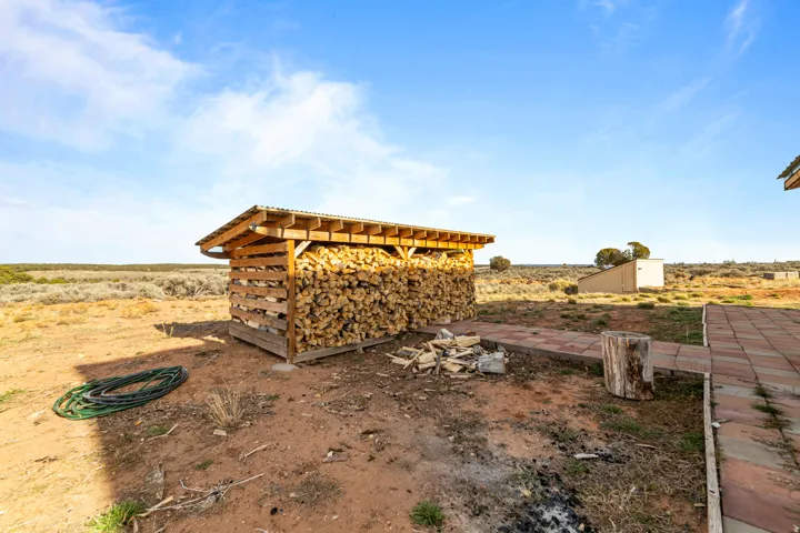 View of yard featuring an outdoor structure for wood storage