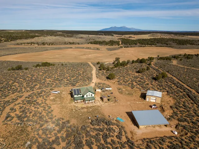 Aerial view of property and surrounding area featuring rural landscape and mountains