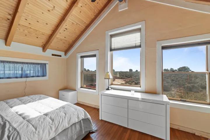 Bedroom featuring wood-type flooring, wooden ceiling, and a ceiling fan