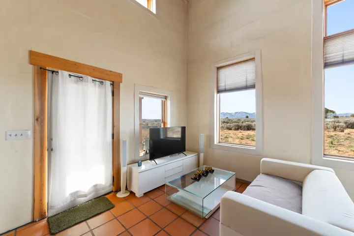 Living room with tile patterned flooring and a towering ceiling