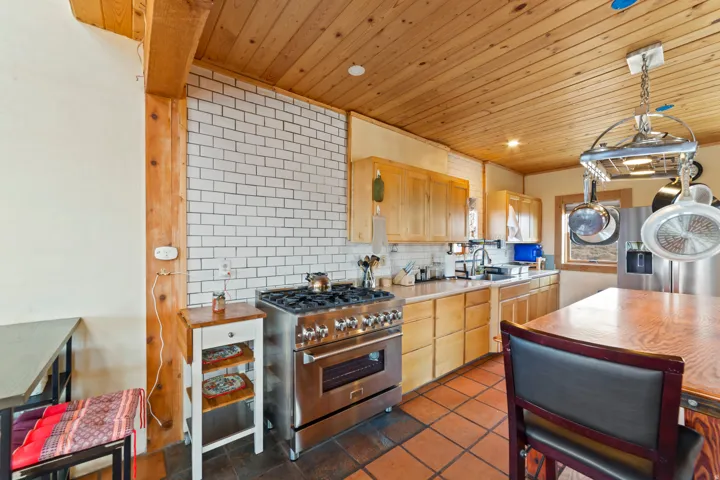 Kitchen featuring decorative backsplash, appliances with stainless steel finishes, wooden ceiling, light countertops, and light brown cabinets