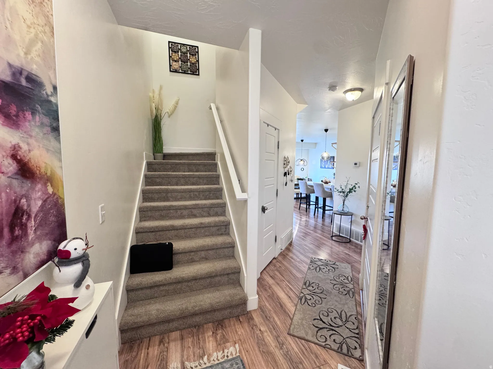 Stairs with wood finished floors and baseboards