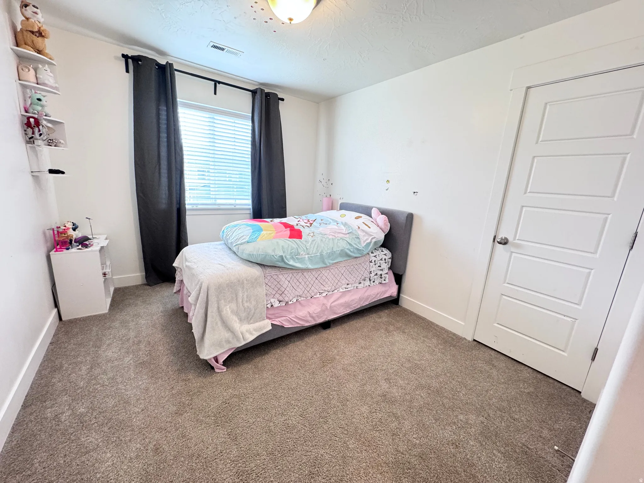 Bedroom featuring carpet flooring and a textured ceiling