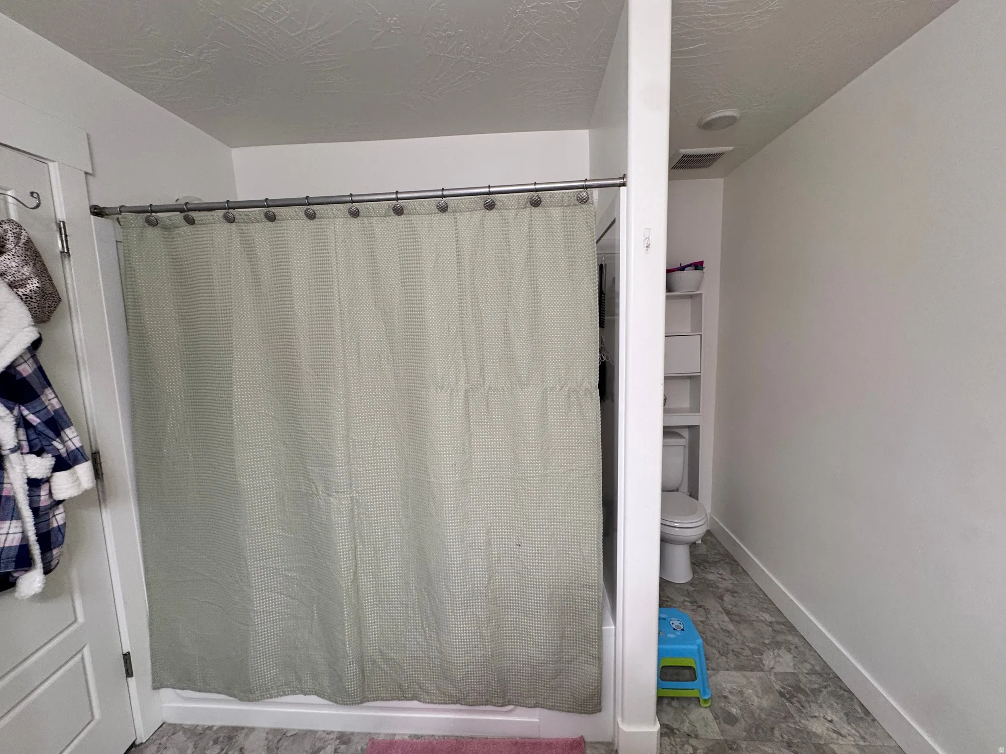 Full bathroom featuring a stall shower and a textured ceiling