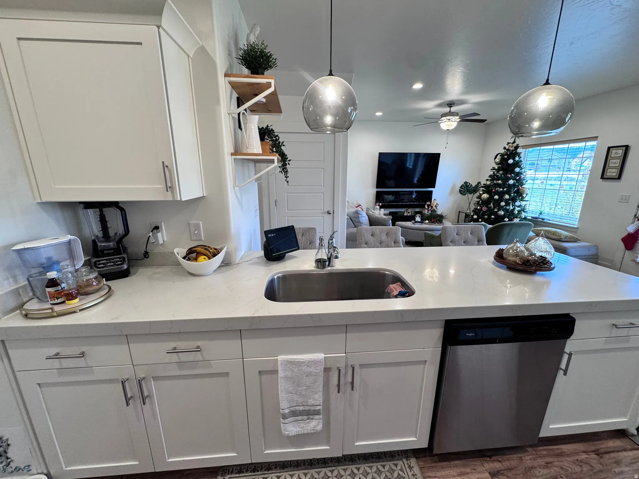 Kitchen featuring open shelves, decorative light fixtures, stainless steel dishwasher, white cabinets, and recessed lighting