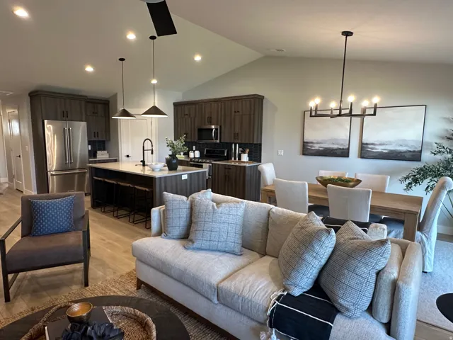 Living area featuring lofted ceiling, light wood finished floors, recessed lighting, and a chandelier