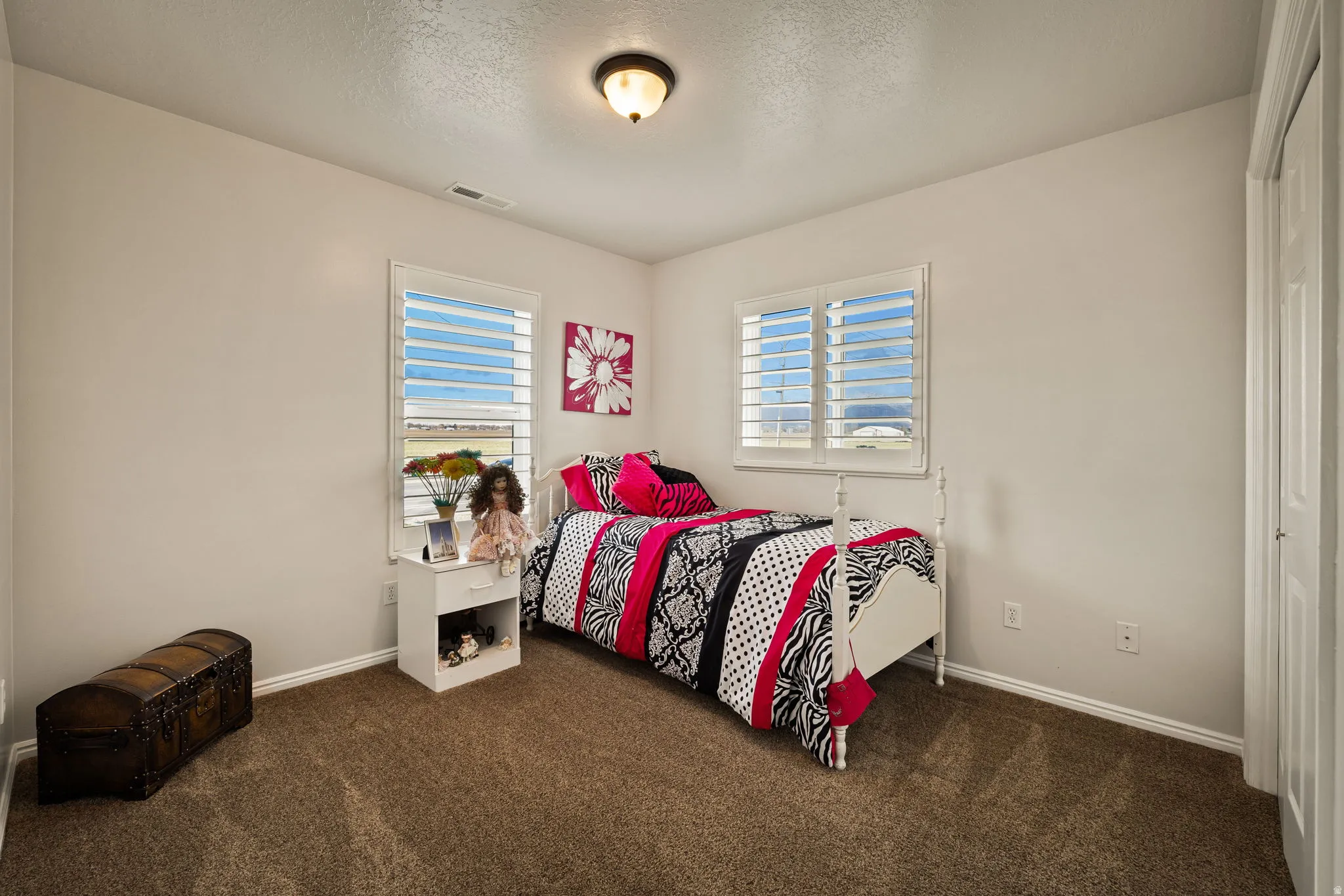 Bedroom with dark carpet and a textured ceiling