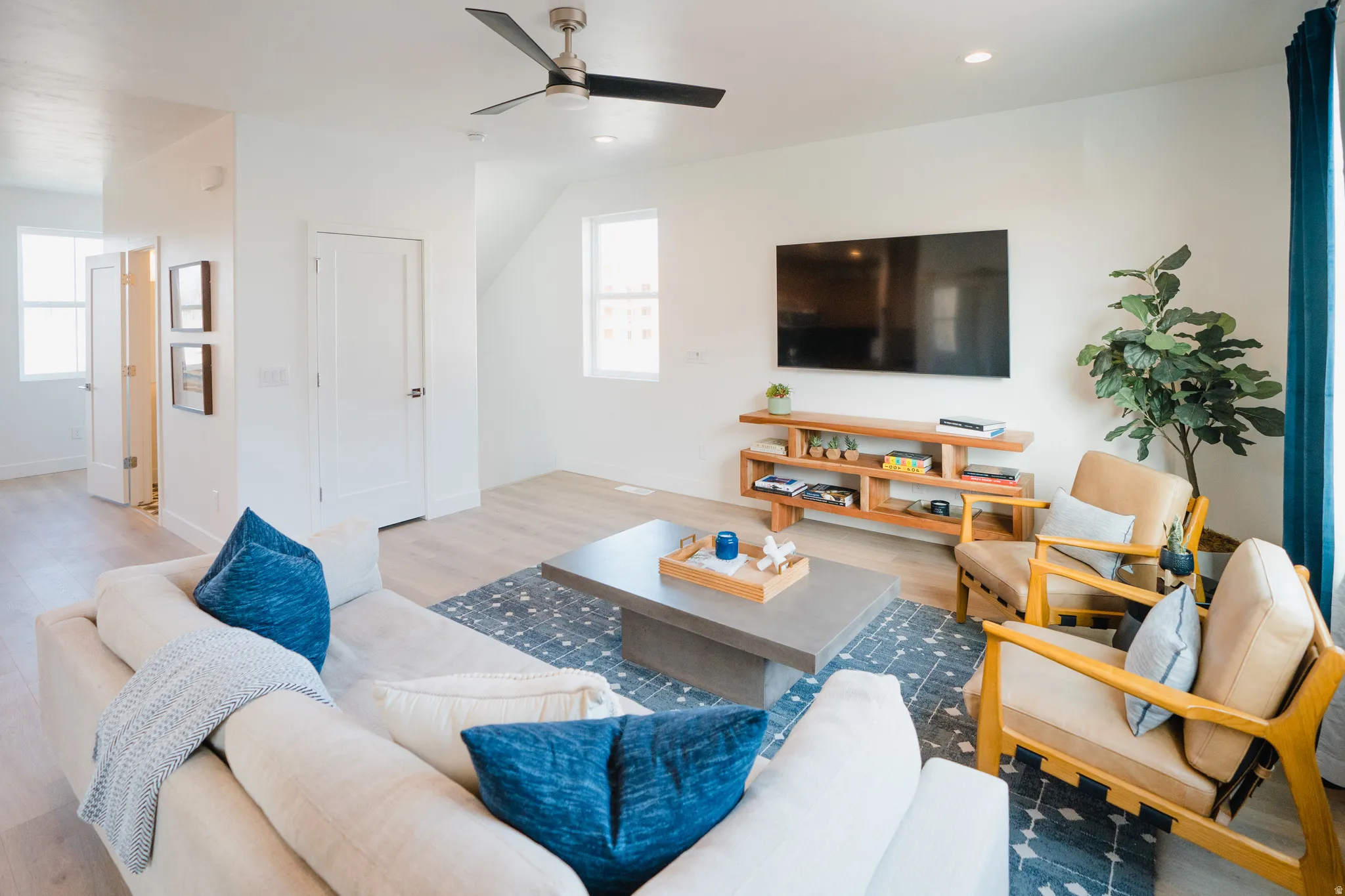 Living area with a ceiling fan, recessed lighting, and wood finished floors
