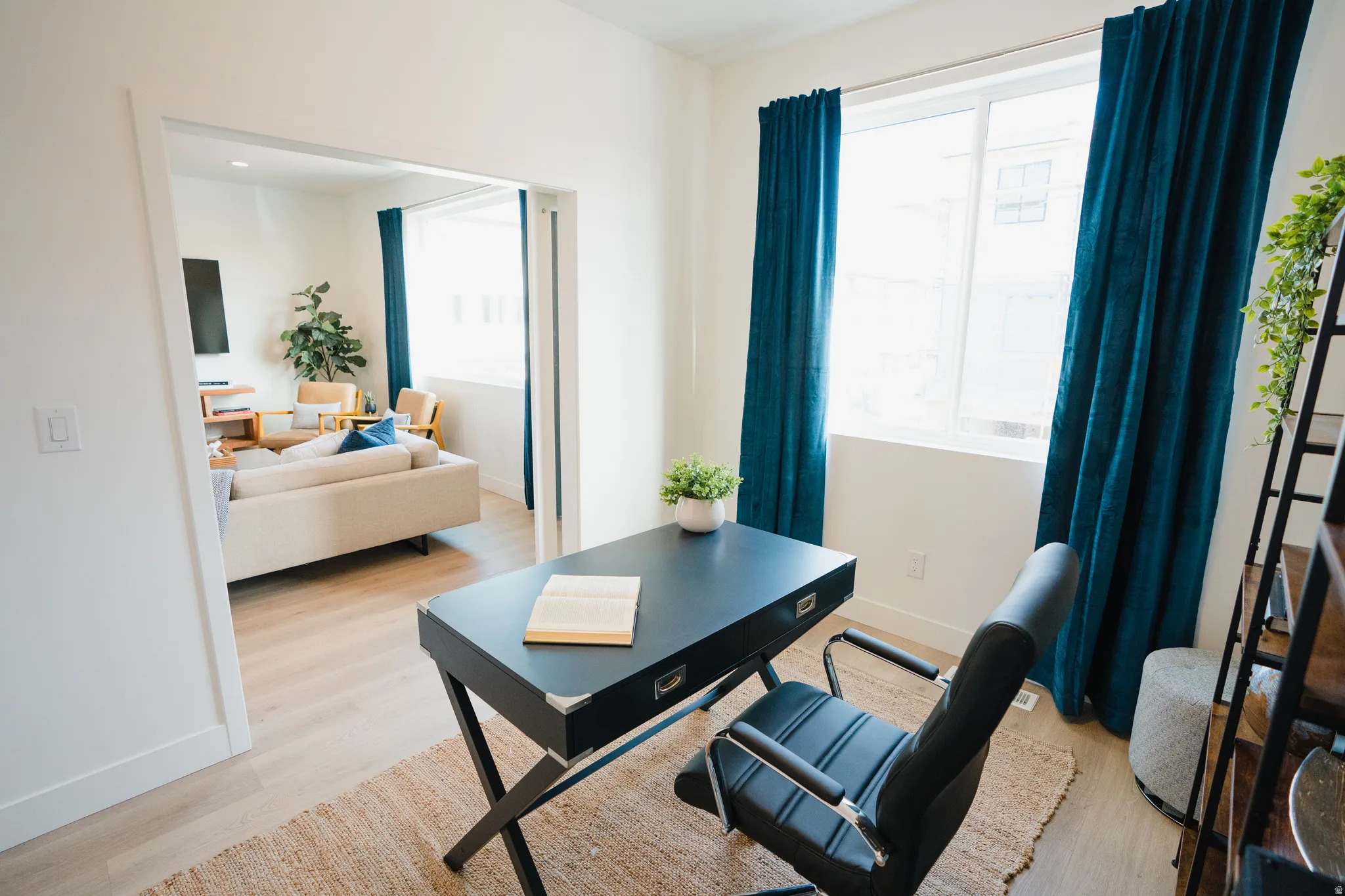 Home office with light wood-style flooring and healthy amount of natural light
