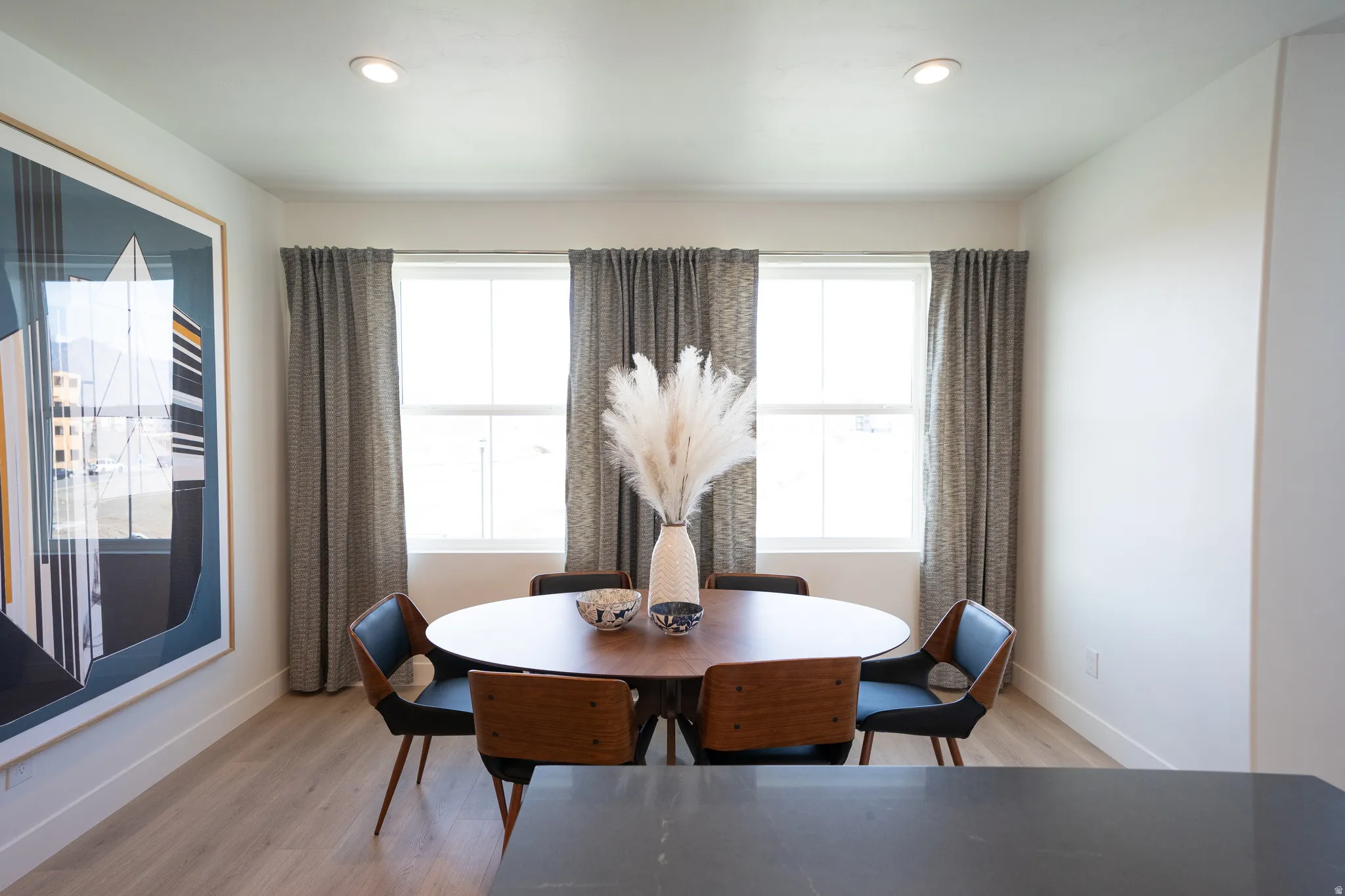 Dining area with light wood-style flooring and recessed lighting