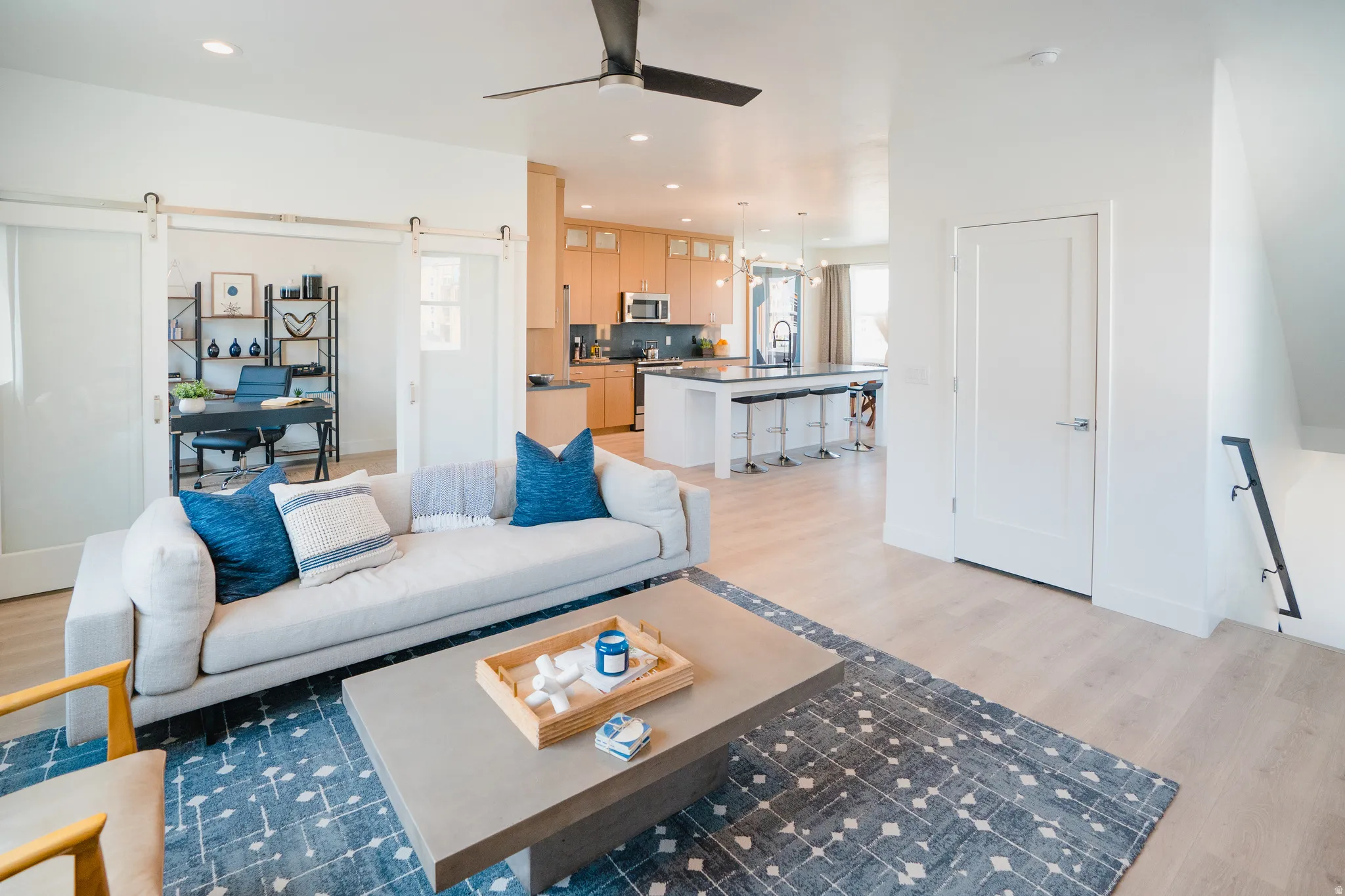 Living room featuring a barn door, light wood-style floors, healthy amount of natural light, ceiling fan, and recessed lighting