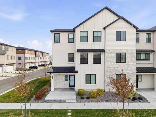 Modern farmhouse with board and batten siding, a standing seam roof, a metal roof, brick siding, and a residential view