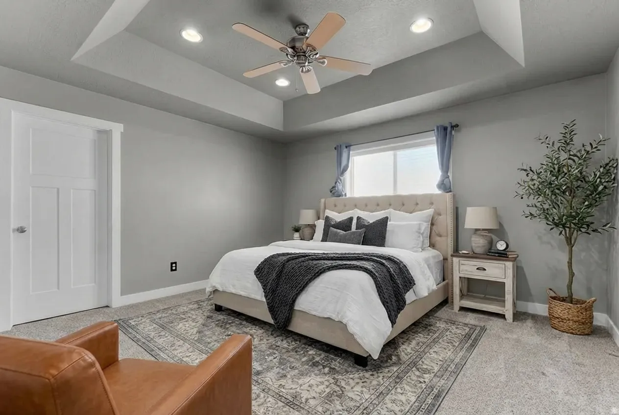 Carpeted bedroom with a raised ceiling, a ceiling fan, and recessed lighting