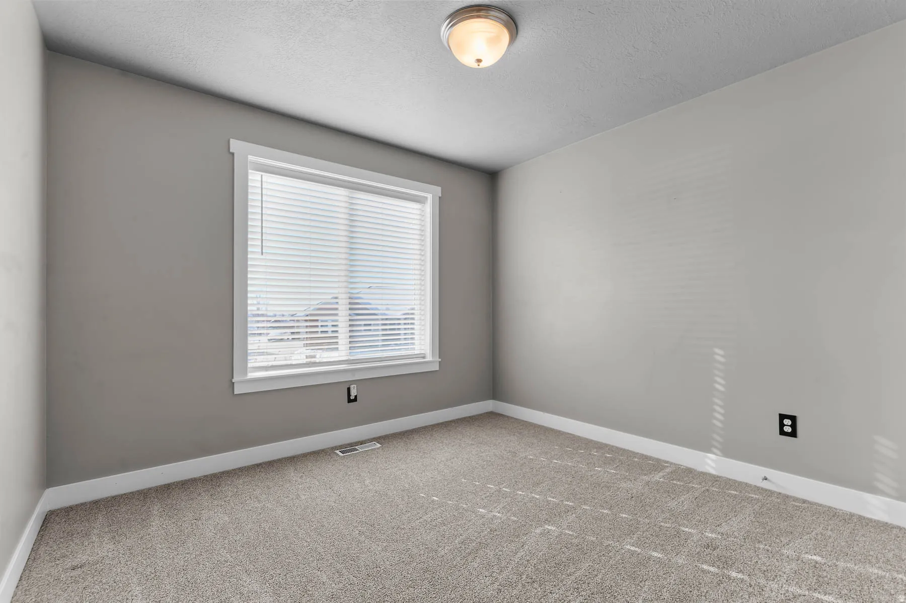 Carpeted empty room featuring baseboards and a textured ceiling