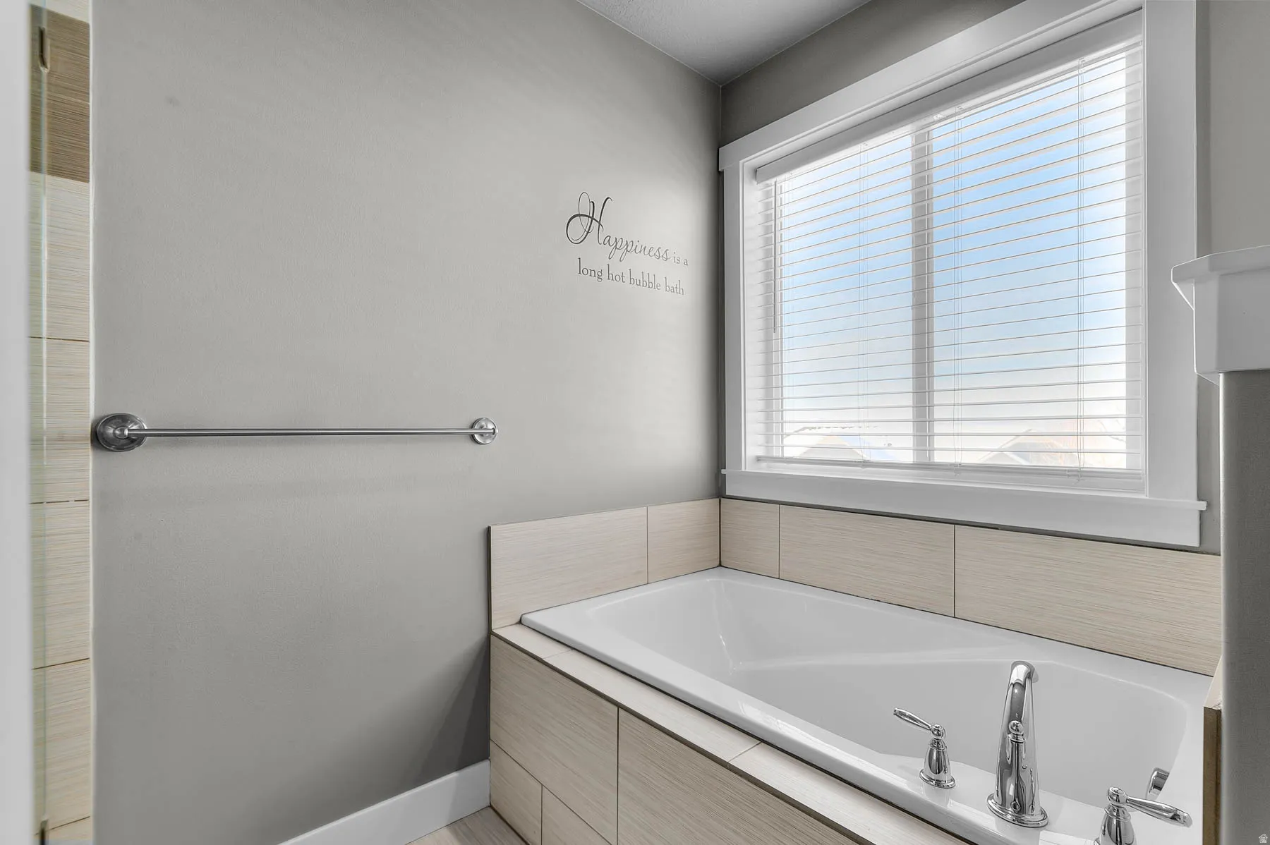 Full bath with a bath and baseboards