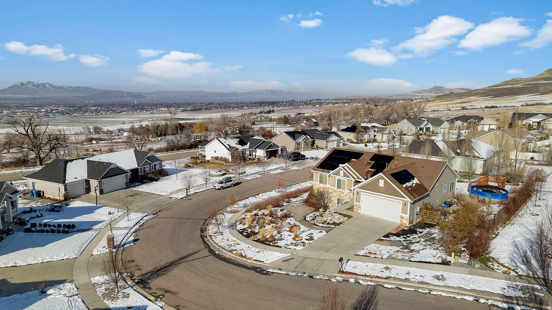 Snowy aerial view featuring a residential view and a mountain view