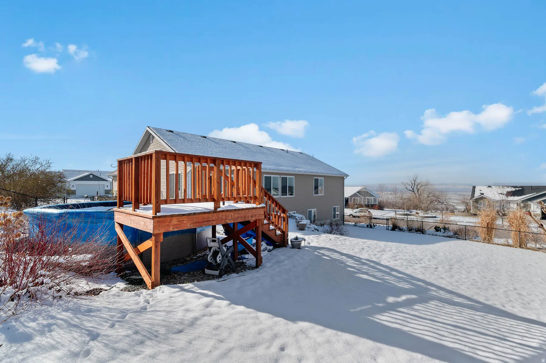 Snow covered property featuring a deck and stairs