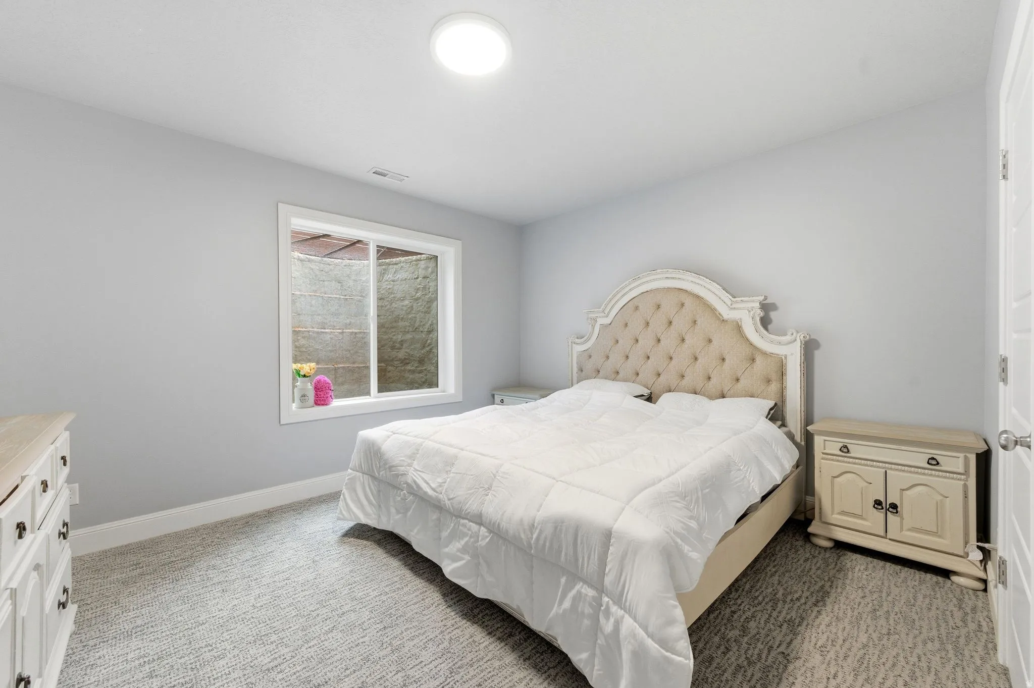 Bedroom featuring light colored carpet