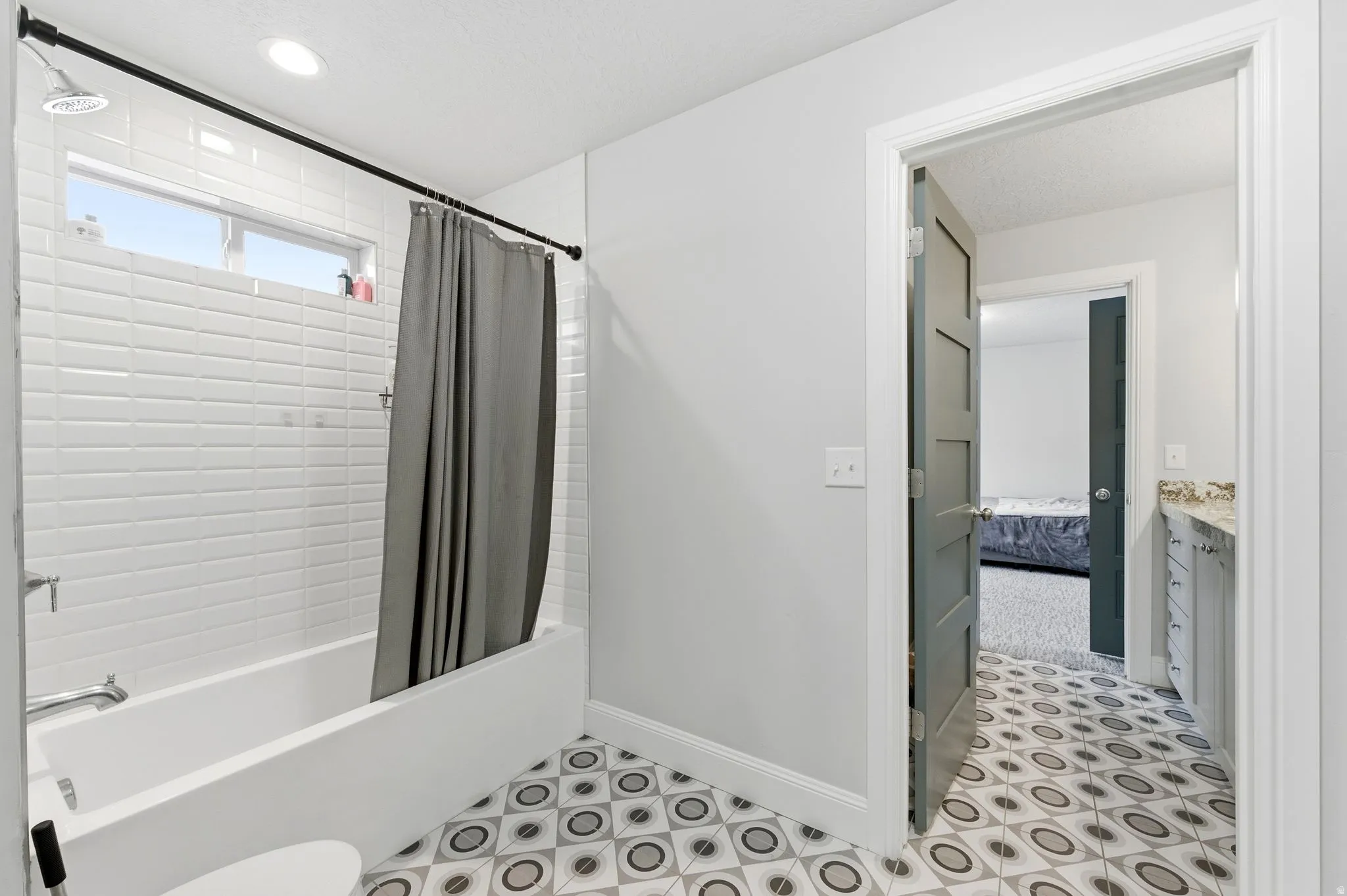 Ensuite bathroom featuring shower / bath combo with shower curtain, vanity, and recessed lighting