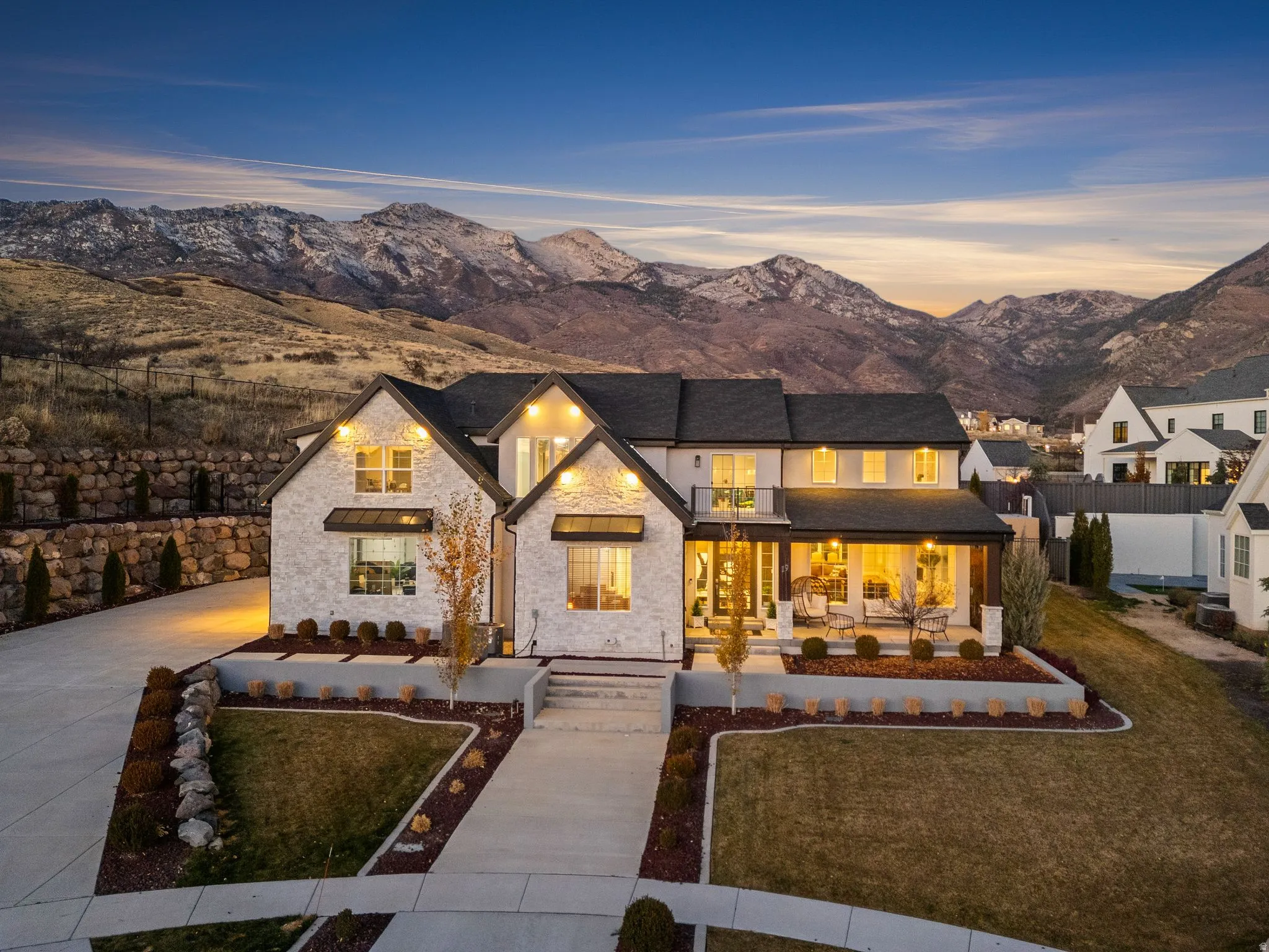 Rear view of property with stone siding, covered porch, a mountain view, and driveway