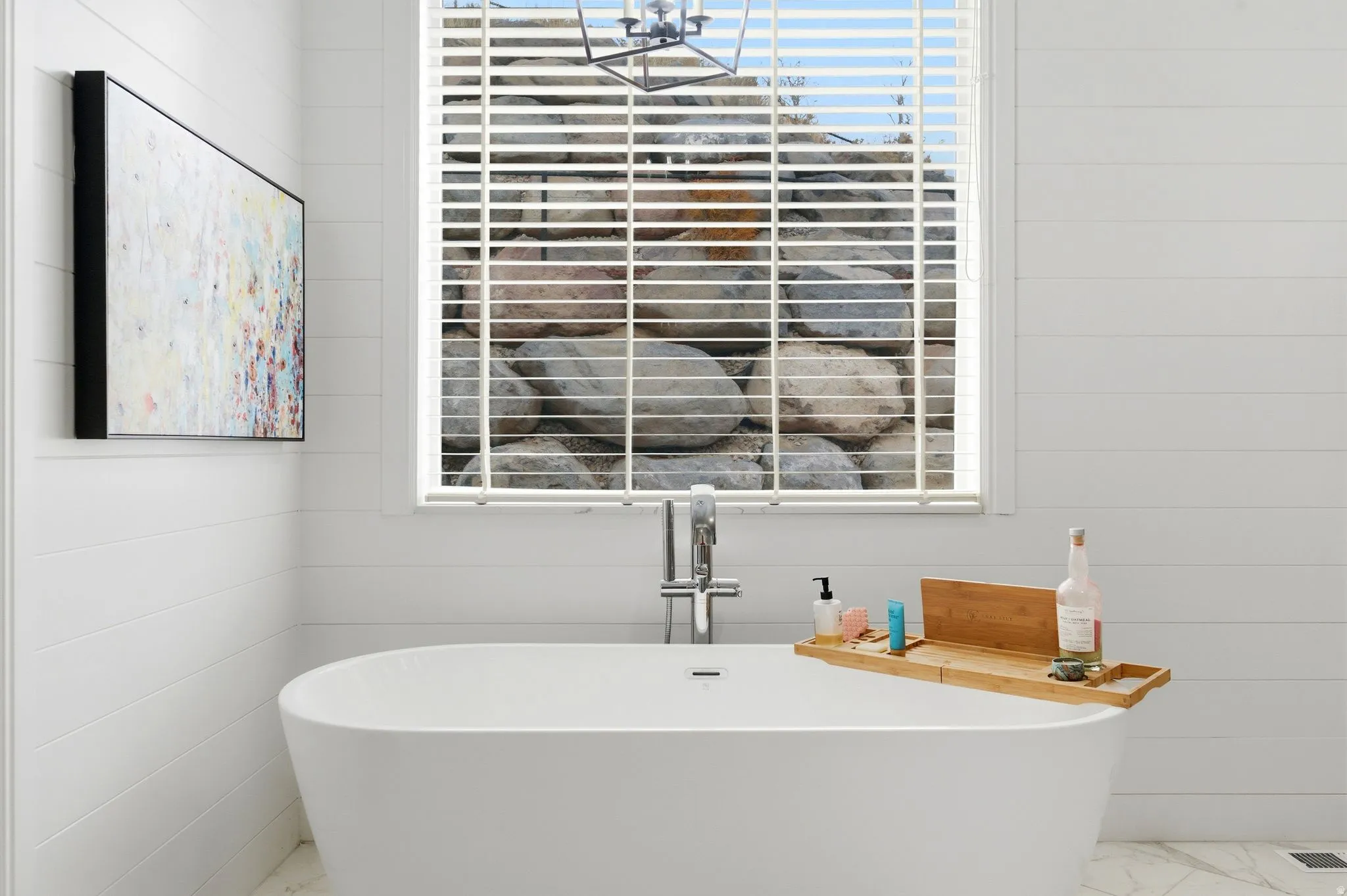 Bathroom with a freestanding bath and marble finish flooring