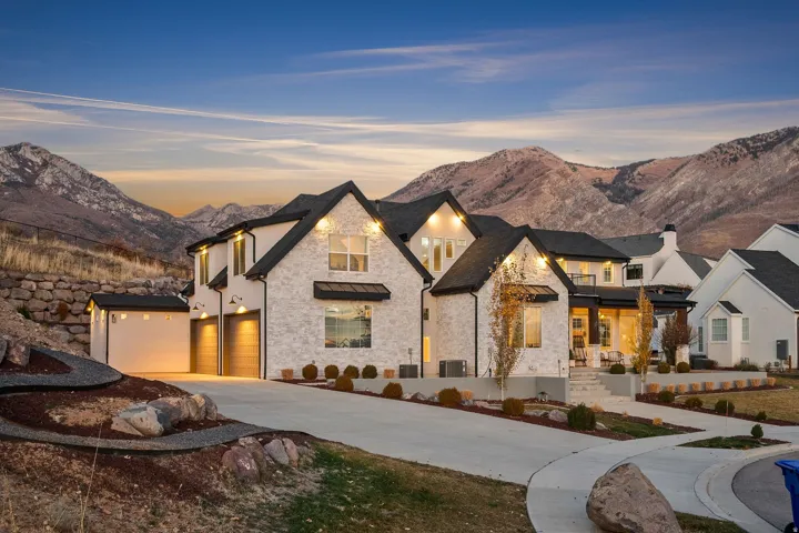 View of front of home featuring driveway, a mountain view, and stone siding
