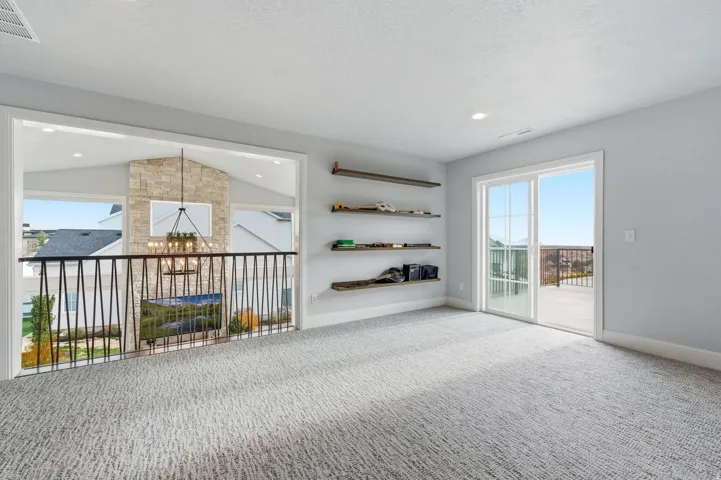 Carpeted spare room featuring a chandelier, vaulted ceiling, a textured ceiling, and recessed lighting