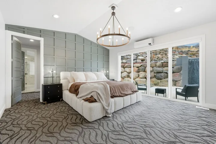 Bedroom featuring vaulted ceiling, access to outside, carpet floors, recessed lighting, and a chandelier