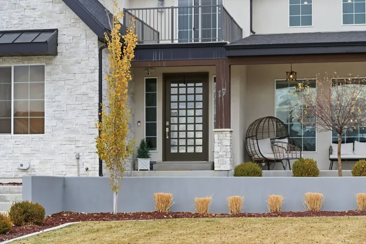 Property entrance with stone siding and stucco siding