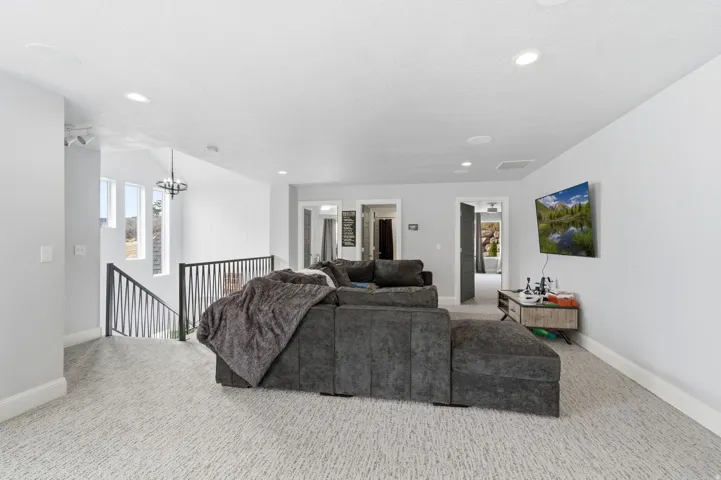 Carpeted living area featuring recessed lighting and a chandelier
