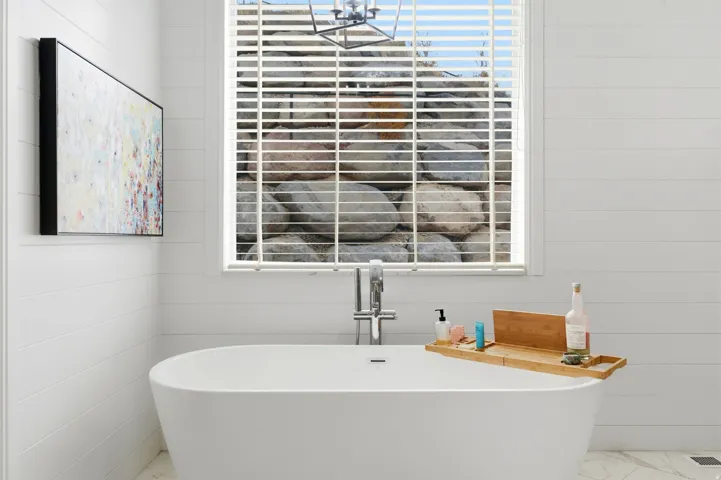 Bathroom with a freestanding bath and marble finish flooring