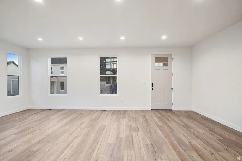 Foyer entrance with light wood-style flooring and recessed lighting