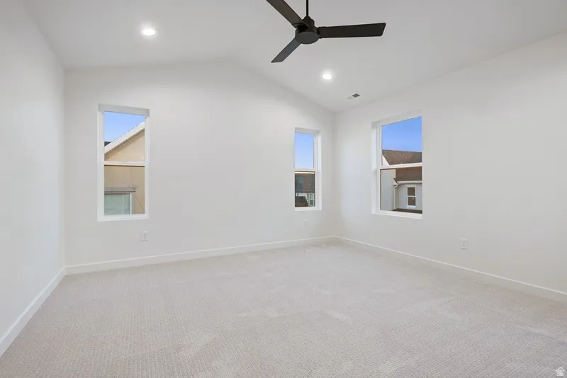 Unfurnished room featuring carpet floors, lofted ceiling, recessed lighting, and a ceiling fan