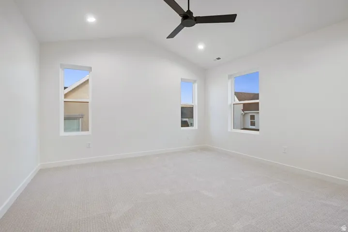 Unfurnished room featuring carpet floors, lofted ceiling, recessed lighting, and a ceiling fan