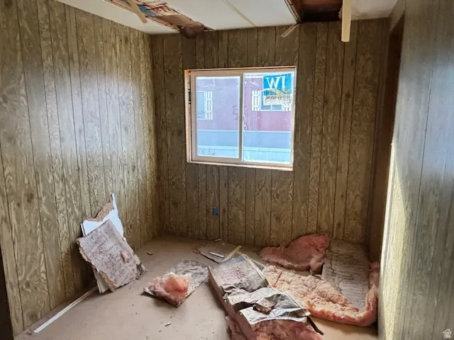 Empty room featuring wood walls