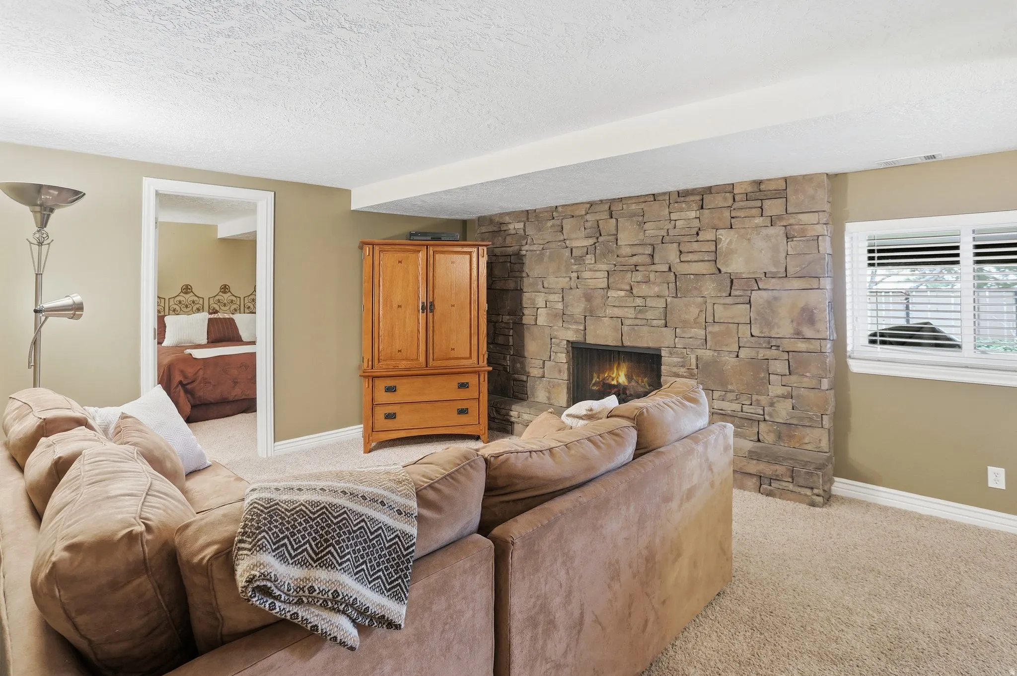 Living room featuring a fireplace, light carpet, and a textured ceiling