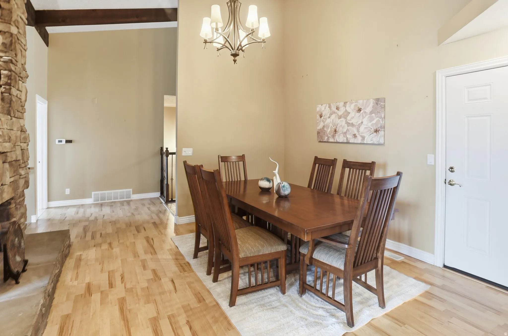 Dining area featuring a chandelier, a towering ceiling, and light wood-style floors