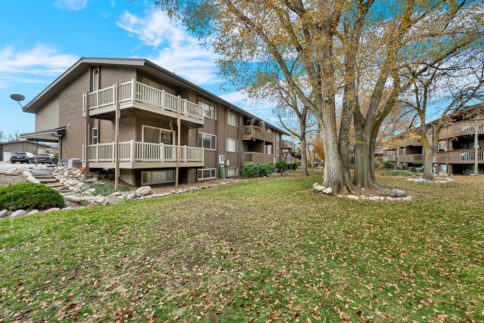 Rear view of property with a lawn and a balcony