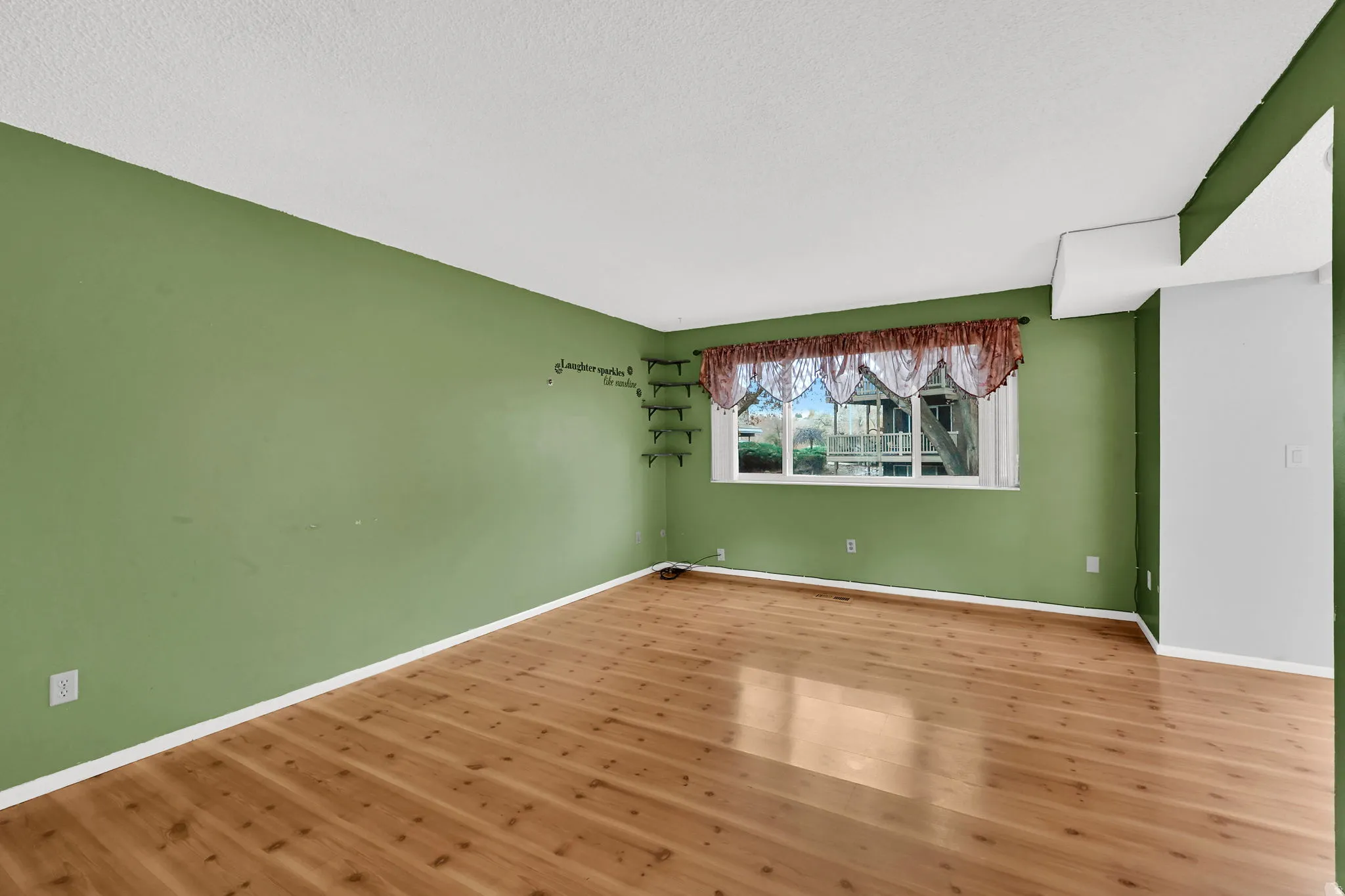 Unfurnished room with wood finished floors and a textured ceiling