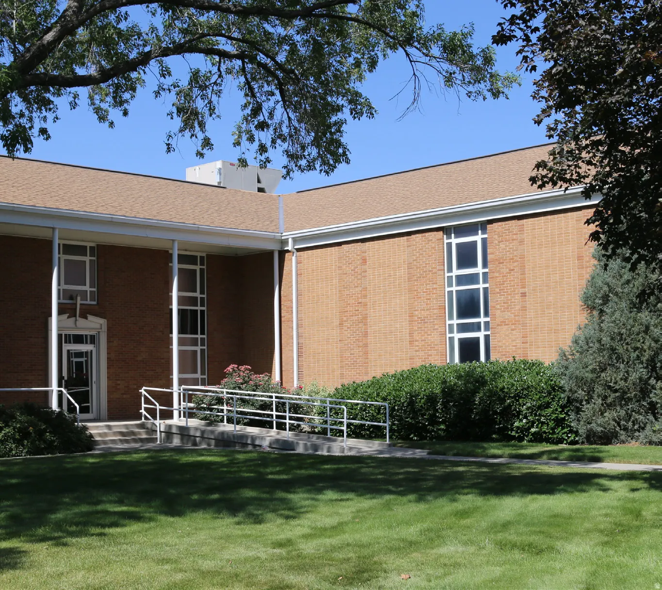 Rear view of property featuring a yard and brick siding