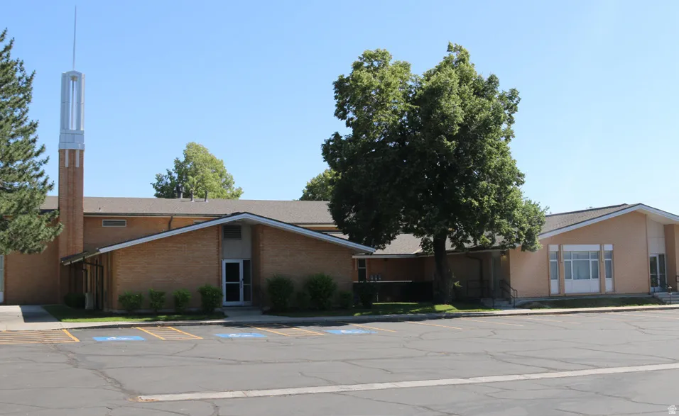 View of building exterior with uncovered parking