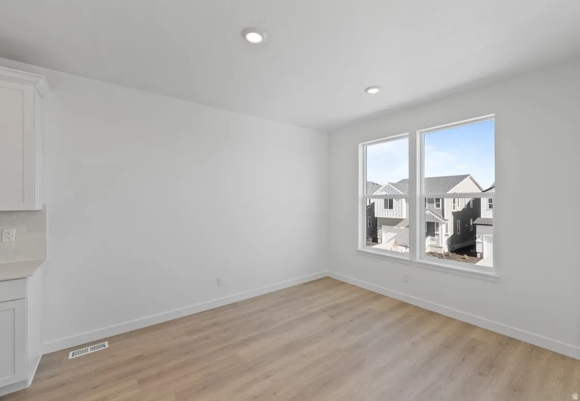Empty room with light wood-type flooring and recessed lighting
